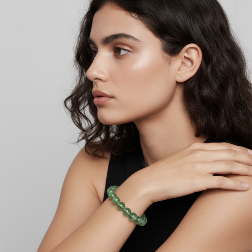 Etheris | Energy Bracelets | Woman wearing a greenrose quartz beaded bracelet on a plain background