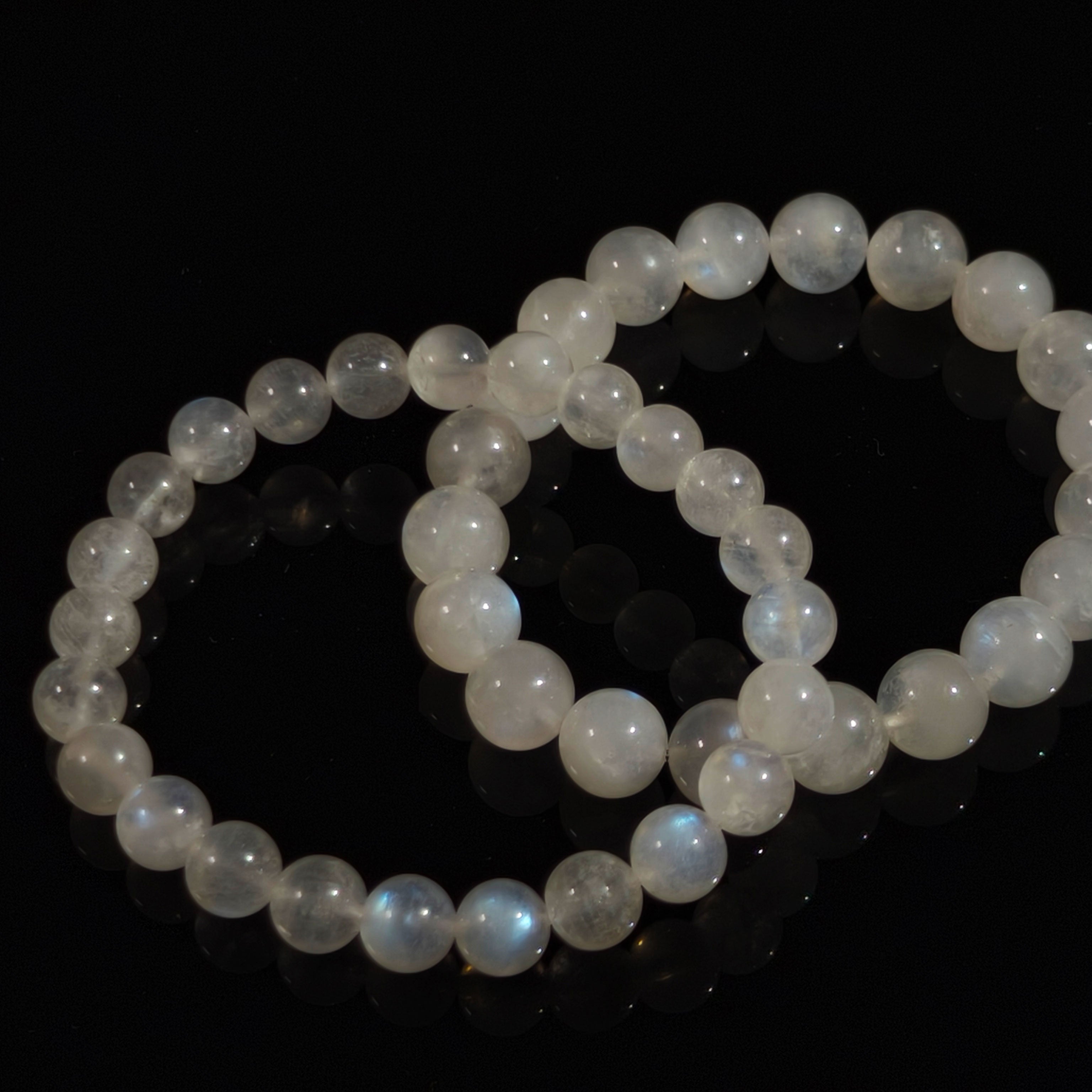 Pair of natural moonstone bead bracelets with polished round stones and blue sheen.